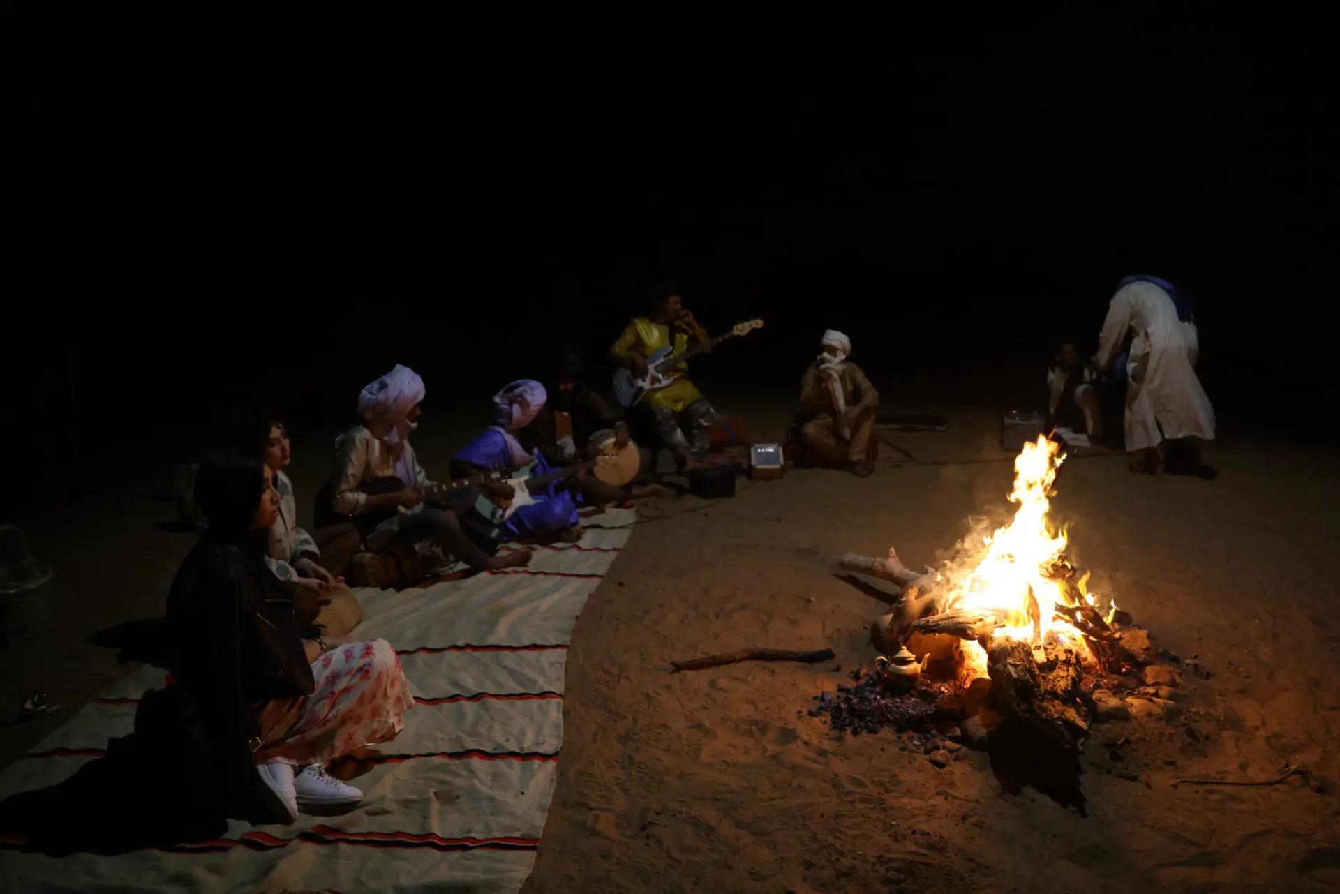 Session musicale nocturne réunissant musiciens locaux et voyageurs autour du feu