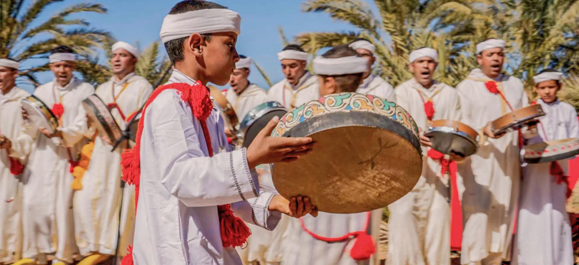 Joueurs de bendir et chanteurs d'Ahidous en habits blancs dans la palmeraie de M'Hamid, lors du Festival Zamane